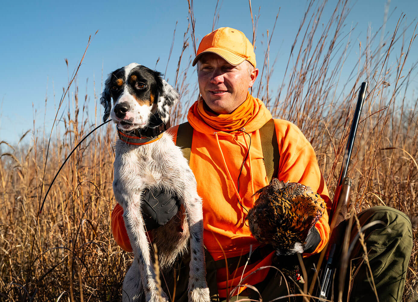 Hunter posing with dog and bird