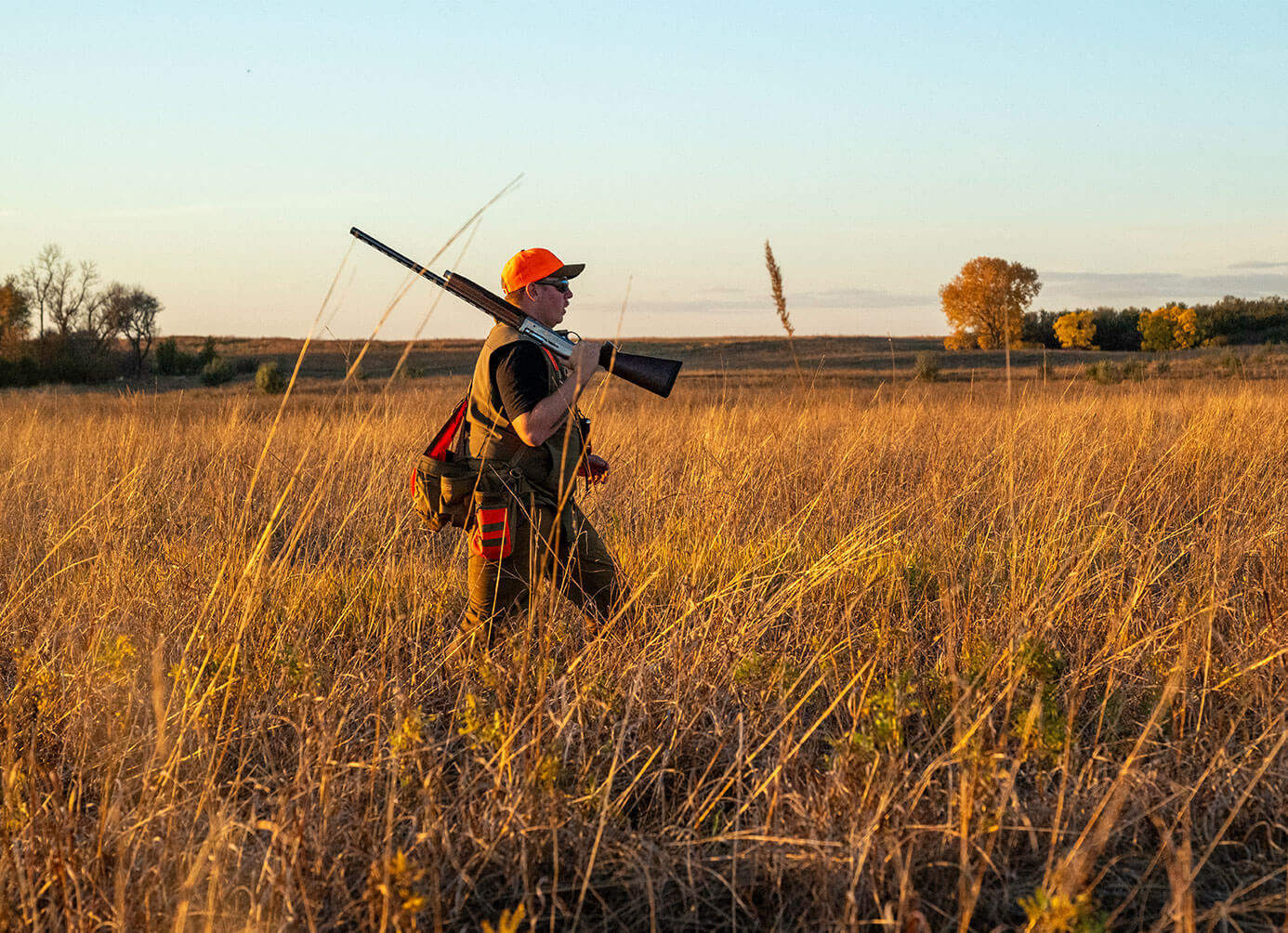 Hunter walking left to right through field