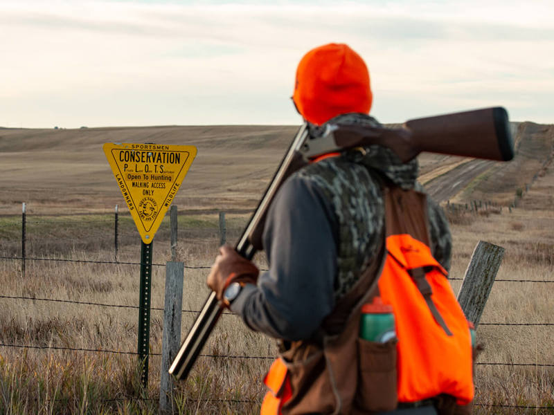 Hunter looking at a sign in a field